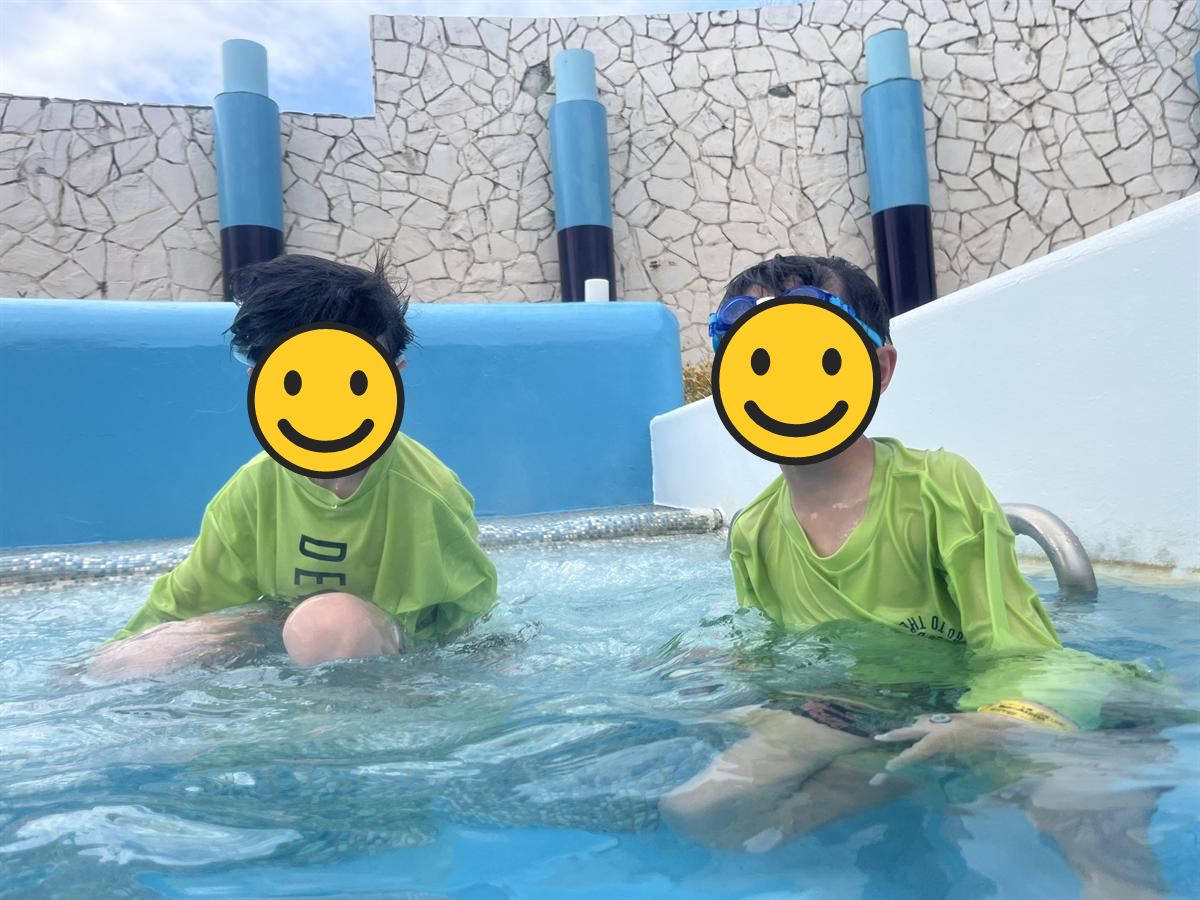 ハワイアンズの屋外プールで水につかる小学生2人
