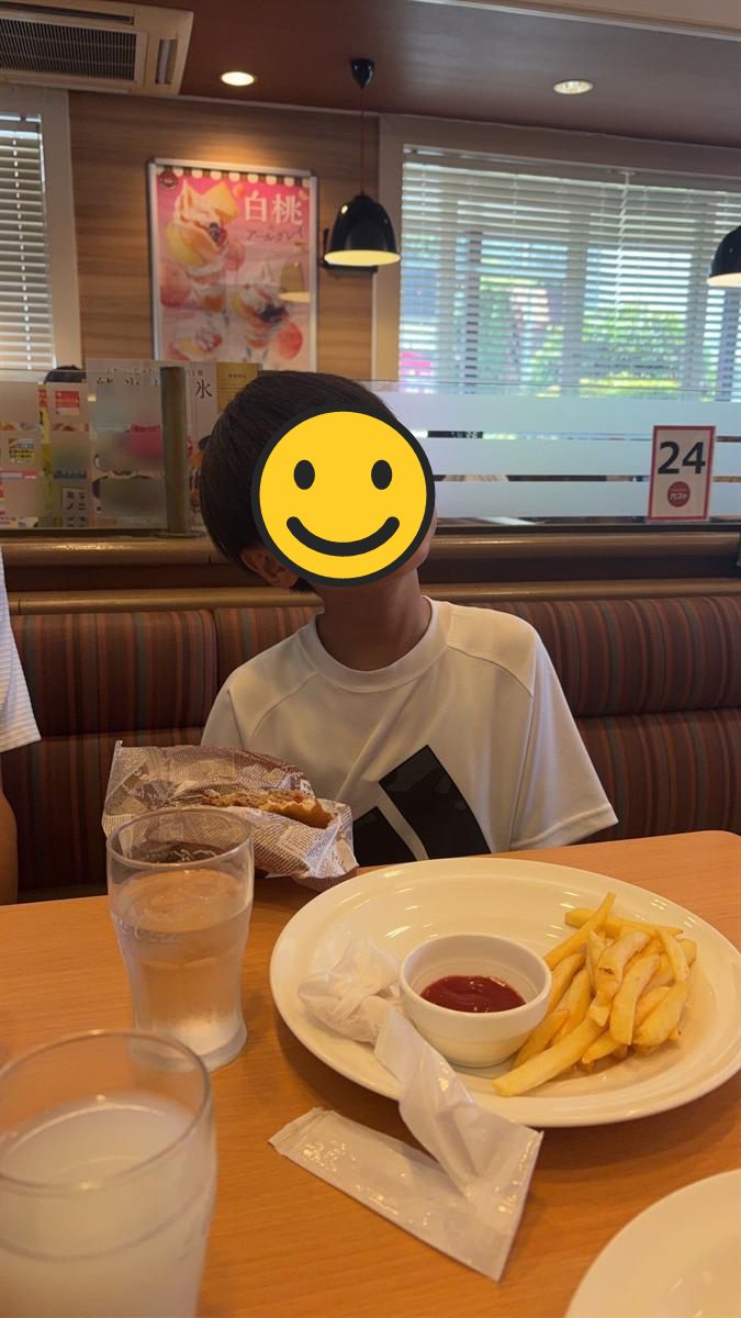 ファミリーレストランのテーブルでフライドポテトを前にした男の子