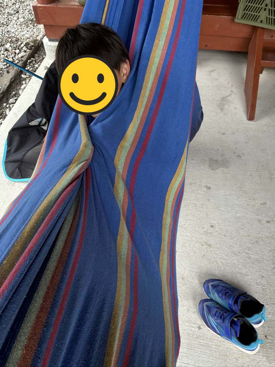 レンタルのハンモックに全身でくるまって笑う子ども