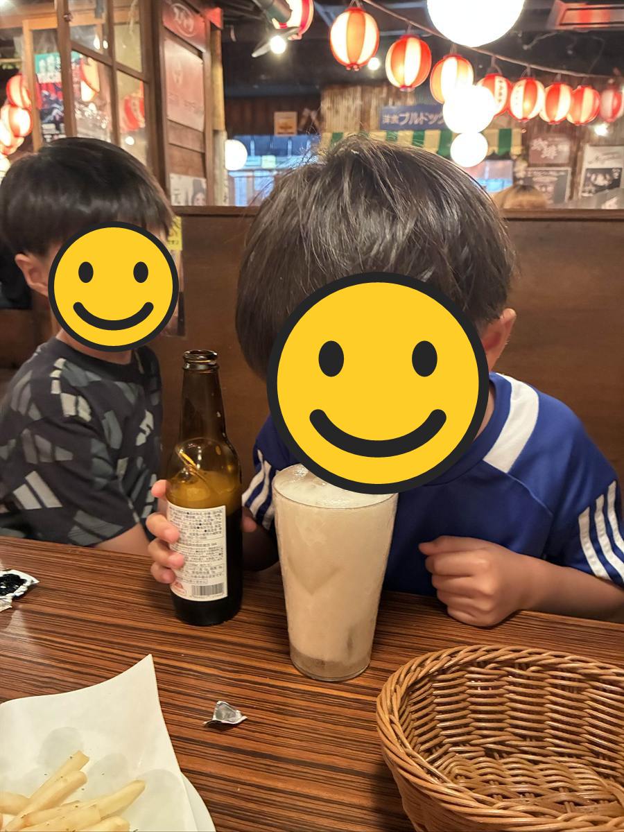 こどもビールの瓶の横で泡の立ったジョッキに口をつける次男