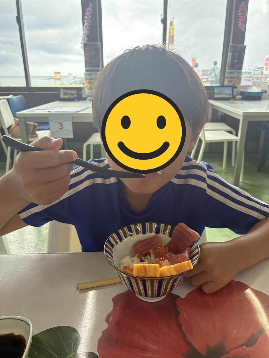 窓際の席で海鮮丼を食べる次男