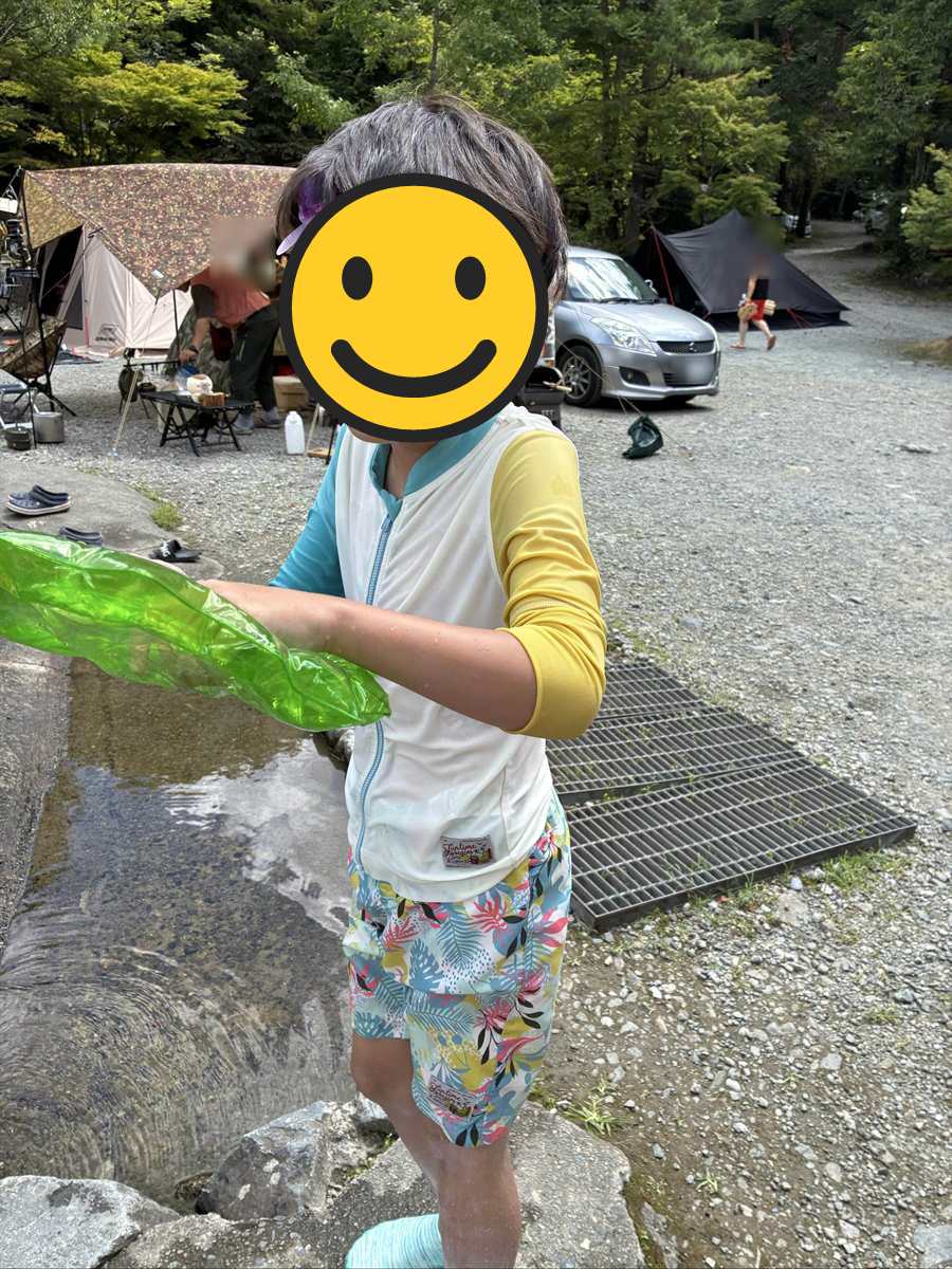 空気を入れて使うエアーシールドを両手で持ってプールへ向かう子ども