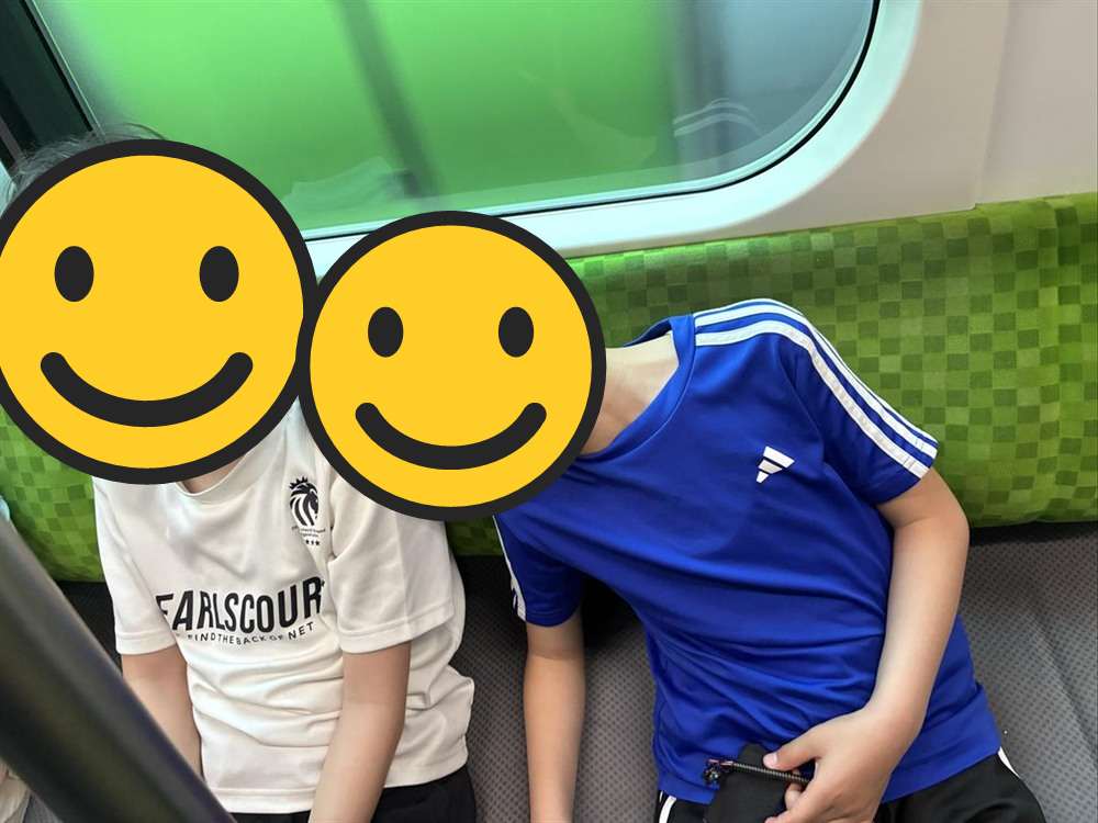 帰りの電車で寄りかかって眠そうにする子どもたち