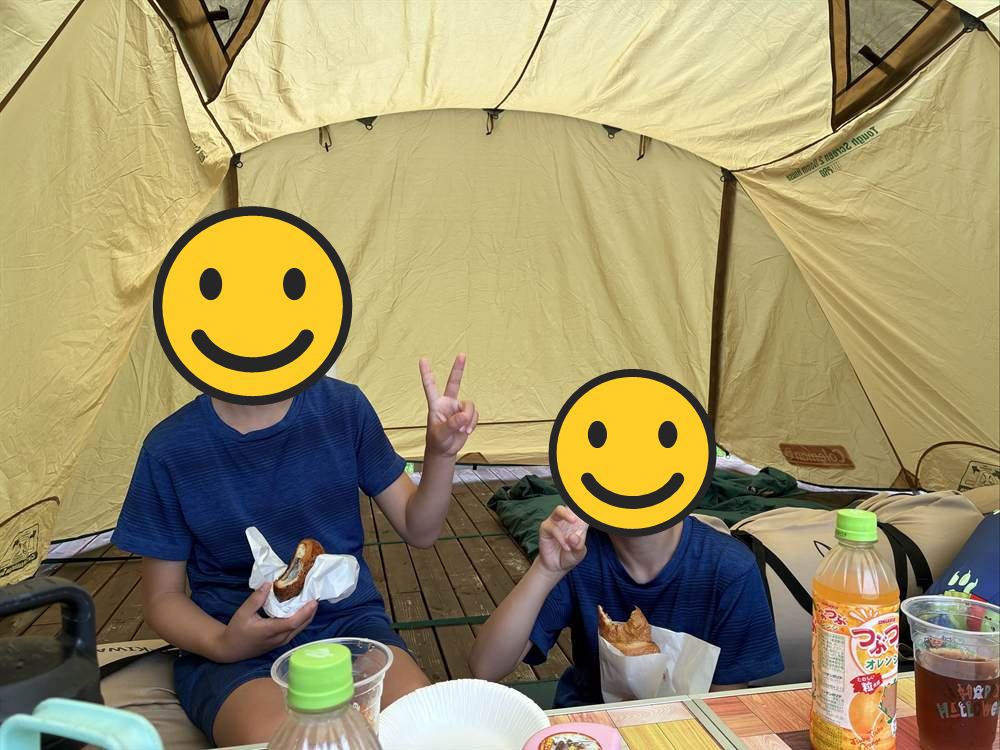 テントの中でパンを食べる兄弟