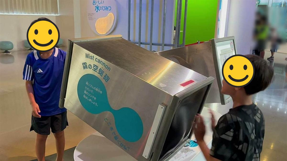 霧の空気砲の装置を叩いて霧のリングを飛ばす子ども2人