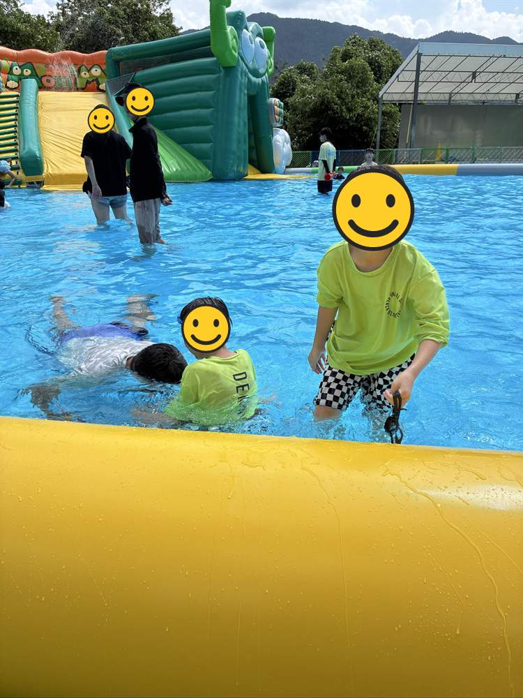 エア遊具のプールでピースをする子ども