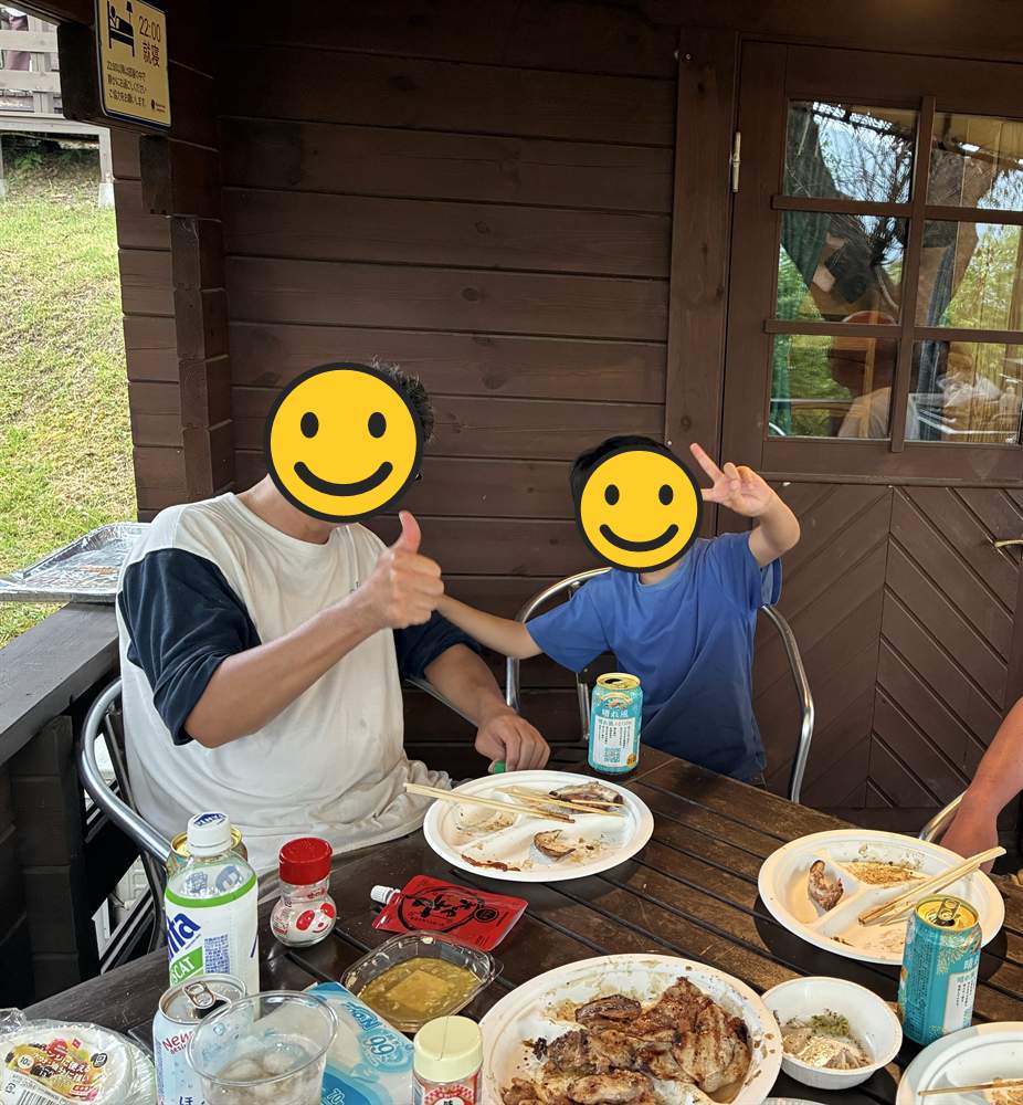 コテージのテラスでBBQをする父と子ども