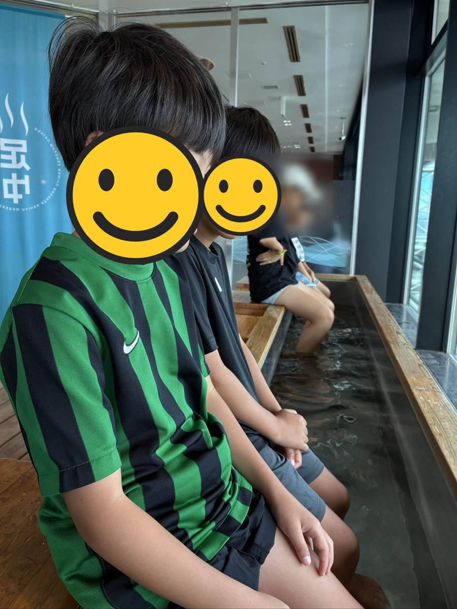 海ほたるの足湯に足を入れて座る子ども2人