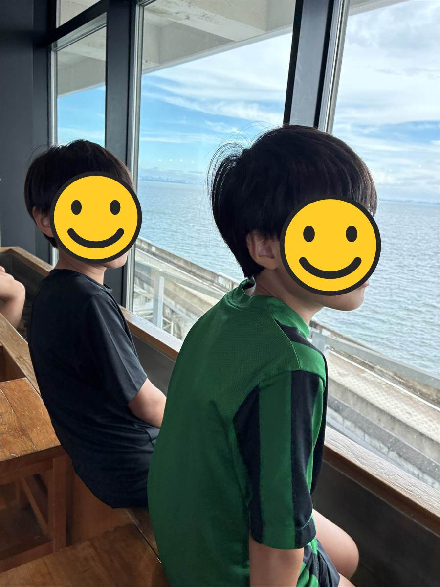海ほたるの大きな窓から東京湾を眺める子ども2人