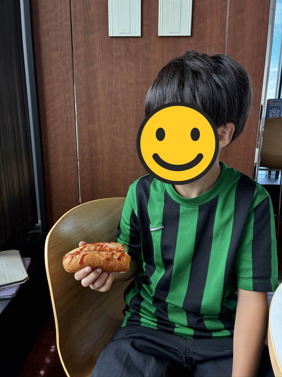 海ほたるの店内でホットドッグを持つ長男