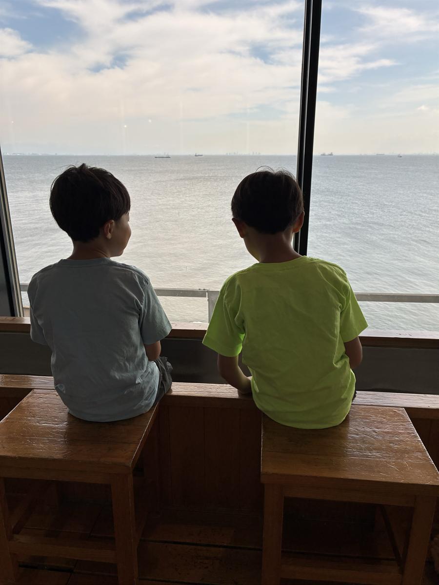 海ほたるの足湯につかって海をながめる兄弟の後ろ姿