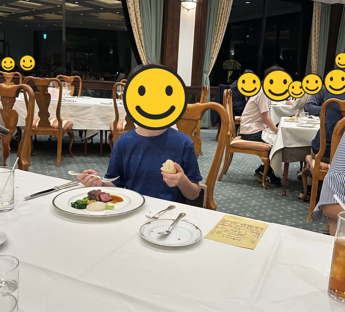 ホテルのレストランでコース料理のメインの肉料理を前にする子ども