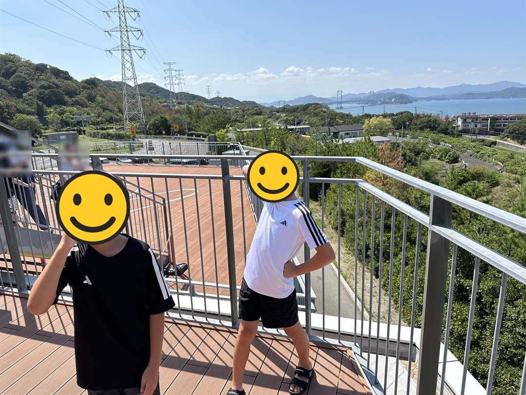 淡路島南PAの展望デッキで変なポーズをとる兄弟。遠くに大鳴門橋と海