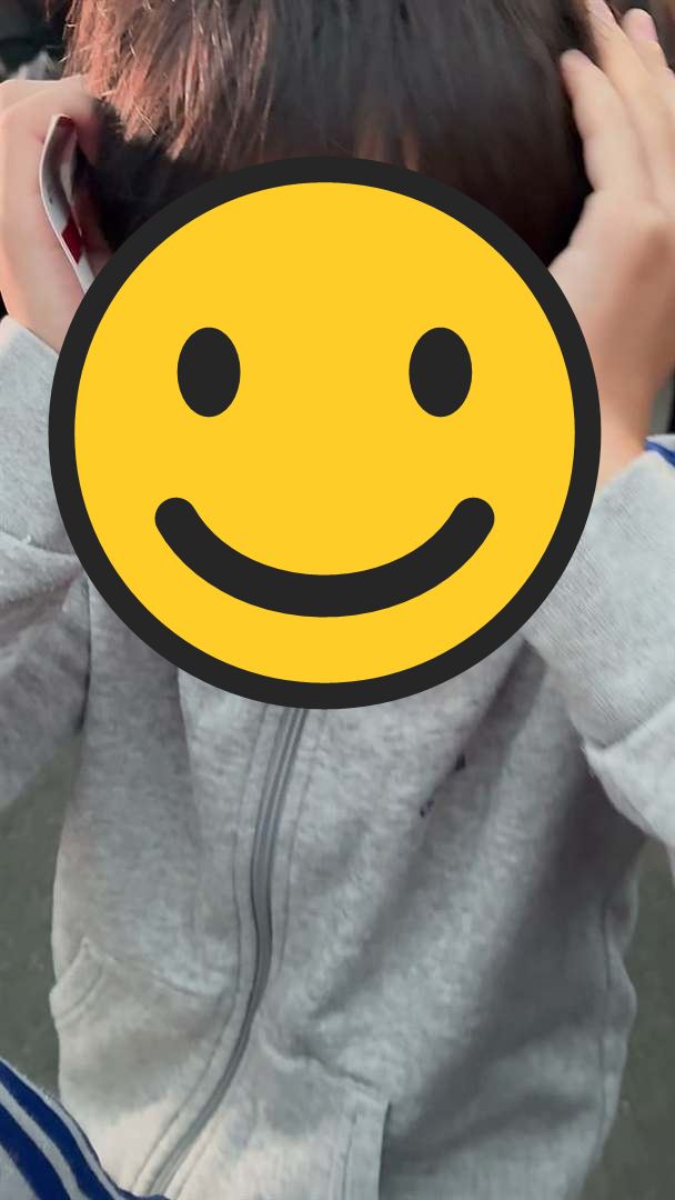 くじ引きの番号がなかなか呼ばれず、両耳をふさいで笑うこども