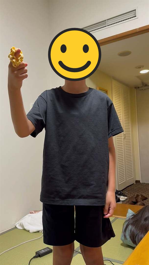 ホテルの和室で、お菓子を手に持って立つこども