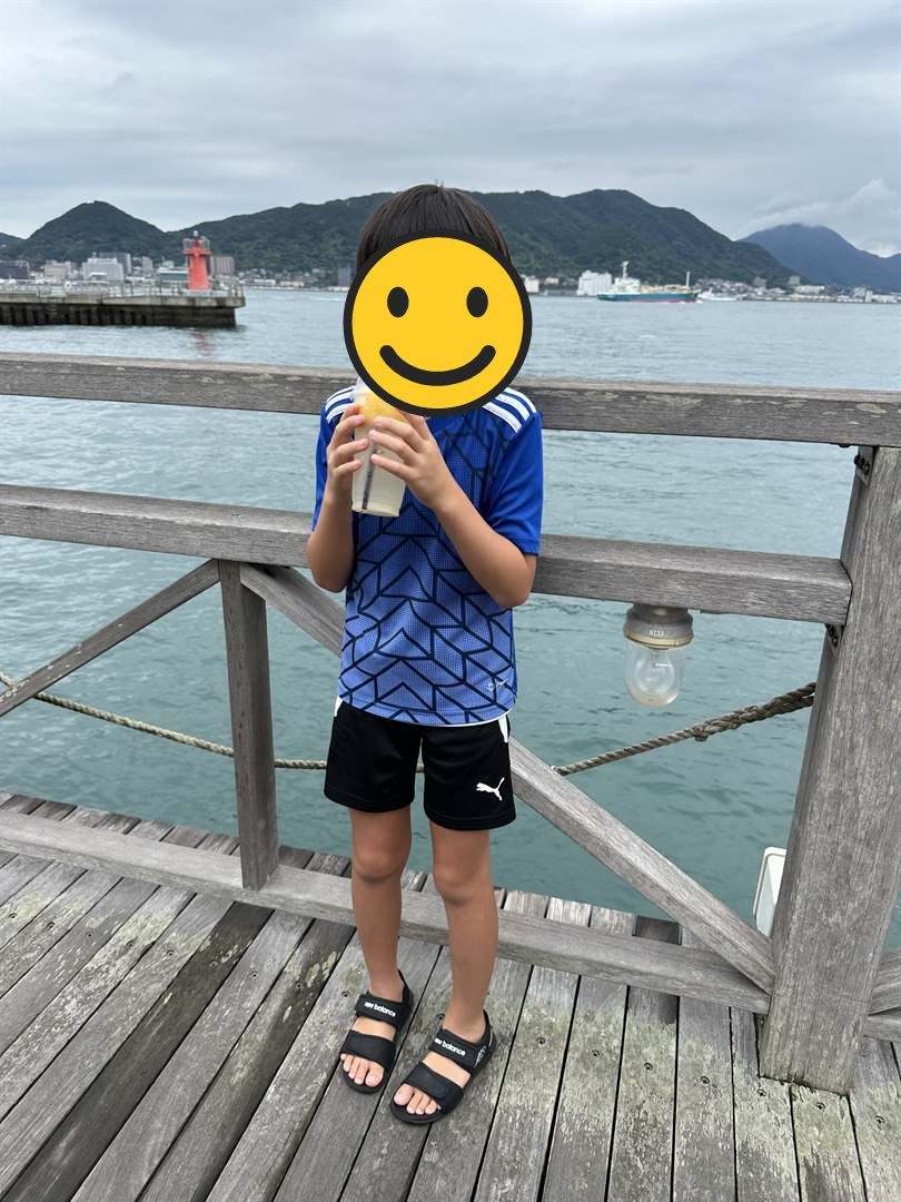 関門海峡沿いの木のデッキでレモンジュースを飲む長男