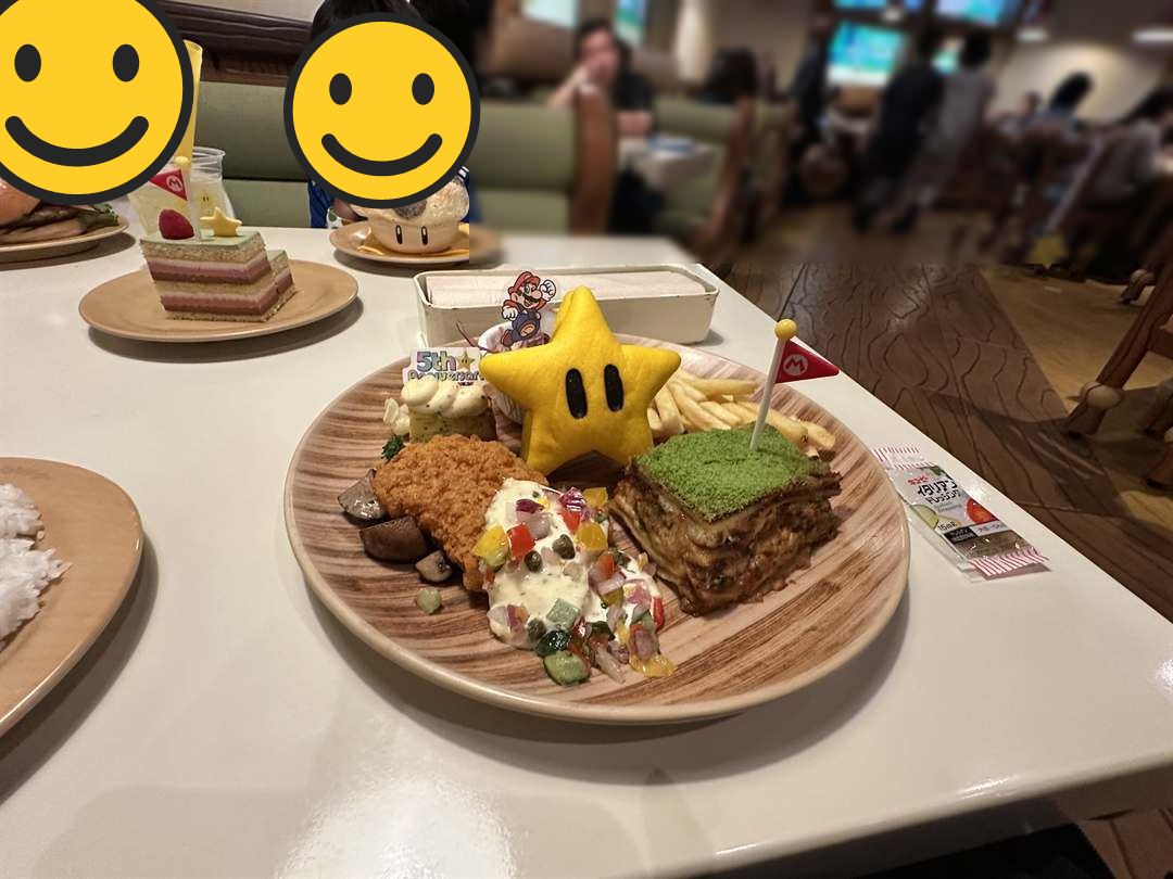 キノピオ・カフェのスーパースターがのったアニバーサリープレートと、キノコのピザボウルを前にする兄弟