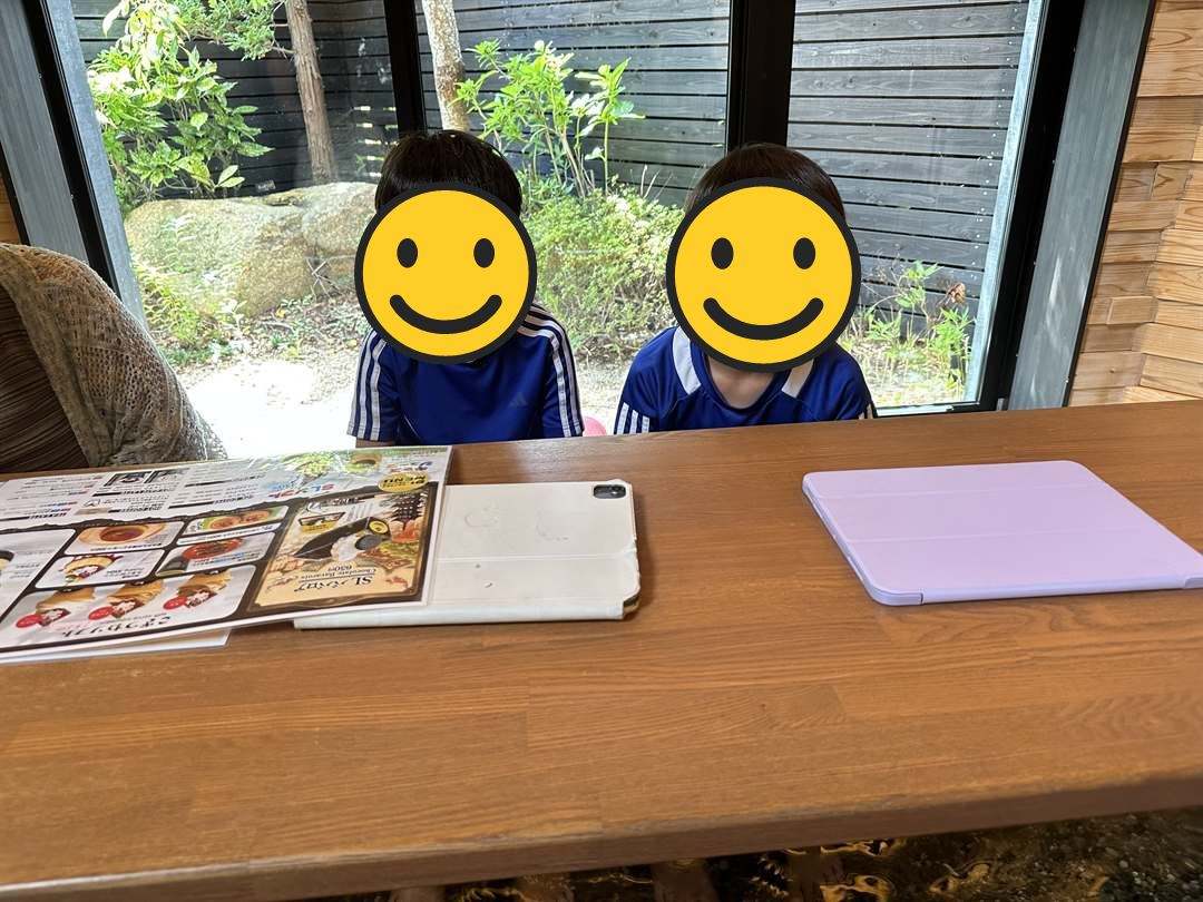 狐の足あとのカフェのテーブルでメニューを見る兄弟
