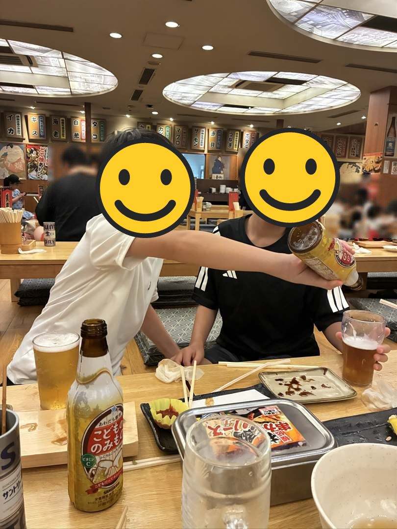 串かつ横綱の座敷で、こどもビールの瓶を兄弟のジョッキに注ぐこども