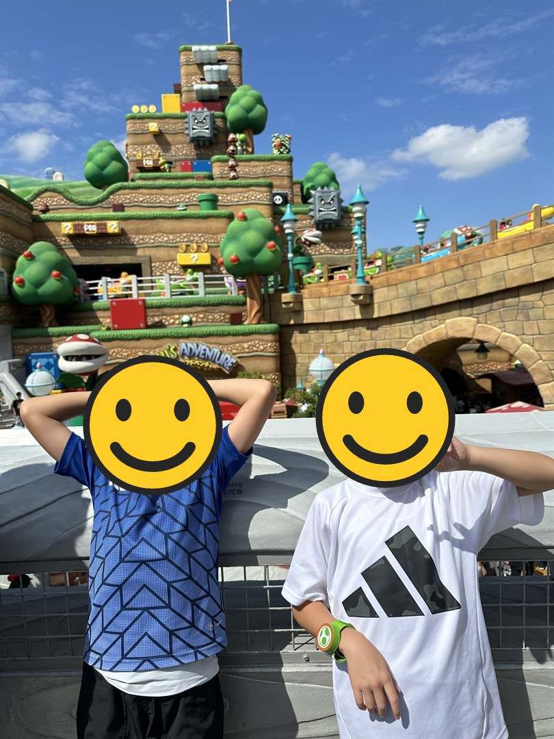 スーパー・ニンテンドー・ワールドのピーチ城や土管を背に、ポーズをとる兄弟