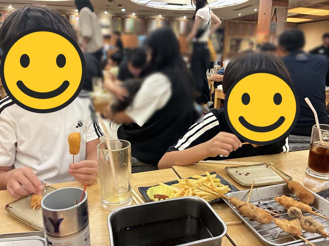 串かつ横綱の広い座敷で、串かつとフライドポテトを食べる兄弟