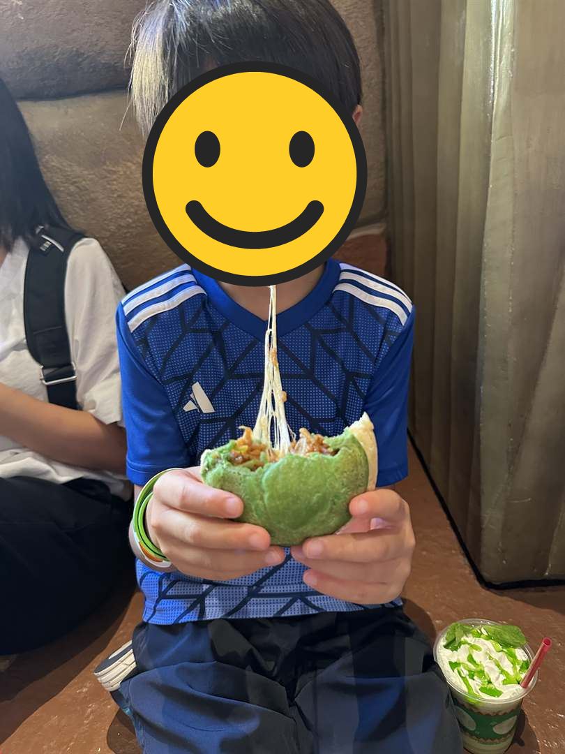 ヨッシーのこうらの形をした緑のカルツォーネにかぶりつき、チーズがのびるこどもと緑のドリンク